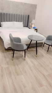 Schlafzimmer mit einem Bett, einem Tisch und Stühlen in der Unterkunft النقره خلف العثيم مول 4 in Ha'il
