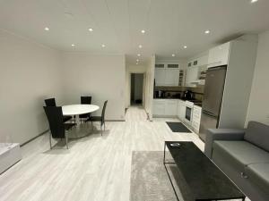 uma cozinha e sala de estar com uma mesa e um sofá em Bright house for short stay em Vantaa