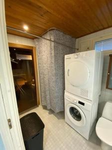 y baño pequeño con lavadora y secadora. en Bright house for short stay en Vantaa