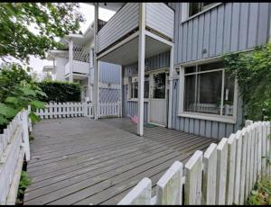 un porche de madera de una casa con una valla blanca en Bright house for short stay en Vantaa
