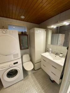 a bathroom with a washing machine and a sink at Bright house for short stay in Vantaa