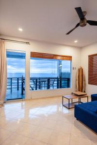 sala de estar con sofá azul y vistas al muelle en Uluwatu Cliff Apartment - 1 BR, en Uluwatu