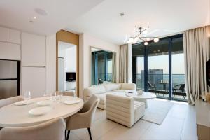 een woonkamer met een tafel en stoelen en een bank bij Livbnb Address JBR Suites - Prime 1 Bedroom in Dubai
