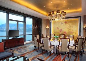a dining room with a table and chairs and a television at DoubleTree by Hilton Chongqing Wanzhou in Wanzhou