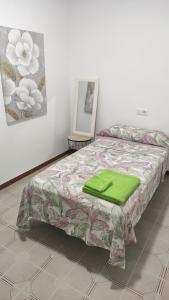 een slaapkamer met een bed met een groen kussen erop bij Diamante en Cambrils Costa Dorada in Cambrils