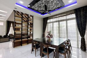 a dining room with a glass table and chairs at 21pax KL Event Bungalow in Ampang