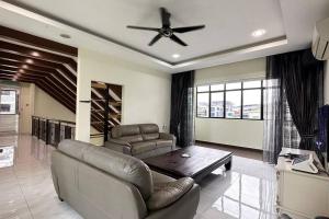 a living room with a couch and a ceiling fan at 21pax KL Event Bungalow in Ampang