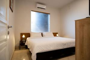 Un dormitorio con una cama grande con ventana. en Uluwatu Cliff Apartment - 1 BR, en Uluwatu 9 fotos más