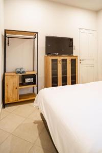 Un dormitorio con un espejo, una cama y un televisor. en Uluwatu Cliff Apartment - 1 BR, en Uluwatu