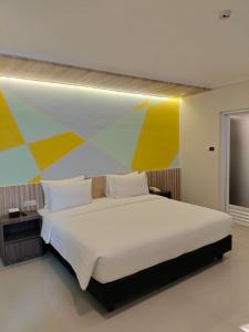 a bedroom with a large bed with a colorful wall at Key Inn Hotel Bogor in Kamparganya