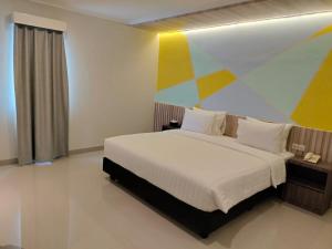 a bedroom with a bed with a colorful painting on the wall at Key Inn Hotel Bogor in Kamparganya