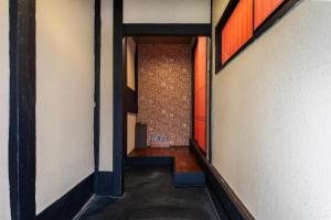 un couloir d'un bâtiment avec une porte ouverte dans l'établissement Shiki Homes NATSU, à Kyoto