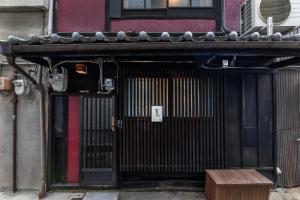 an entrance to a building with a door and a bench at Shiki Homes NATSU in Kyoto