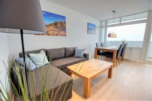 ein Wohnzimmer mit einer Couch und einem Tisch in der Unterkunft Ferienpark - Haus C, App 0C1109 in Heiligenhafen