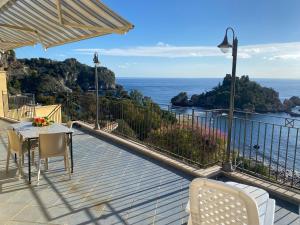 balcón con mesa, sillas y vistas al océano en SUITE ISOLA BELLA, en Taormina