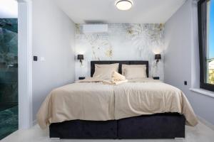 a bedroom with a large bed with white sheets at Deluxe villa with heated pool, whirpool, sea view, beautiful beach IV - by Traveler tourist agency Krk ID 2403 in Krk +46 photos