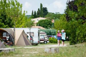 duas mulheres em frente a um acampamento em Camping Forcalquier les Routes de Provence em Forcalquier