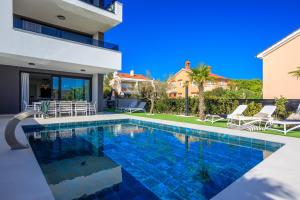 a swimming pool in the backyard of a villa at Deluxe villa with heated pool, whirpool, sea view, beautiful beach IV - by Traveler tourist agency Krk ID 2403 in Krk