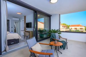 a bedroom with a balcony with a bed and a television at Deluxe villa with heated pool, whirpool, sea view, beautiful beach IV - by Traveler tourist agency Krk ID 2403 in Krk