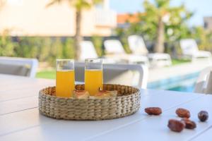 a basket of bread and two glasses of beer on a table at Deluxe villa with heated pool, whirpool, sea view, beautiful beach IV - by Traveler tourist agency Krk ID 2403 in Krk