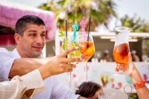 two people holding up two drinks in their hands at Don Antonio Glamping Village in Giulianova