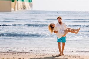 Un uomo e una donna in piedi sulla spiaggia di Don Antonio Glamping Village a Giulianova