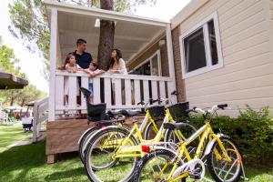 a family on the porch of a house with bikes at Don Antonio Glamping Village in Giulianova