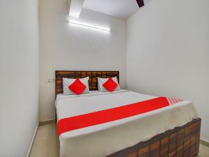 a bedroom with a bed with red pillows at OYO Flagship Hotel Dream Palace in New Delhi