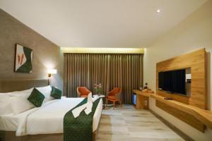 Habitación de hotel con cama y TV en Hotel Park Inn, en Nellore
