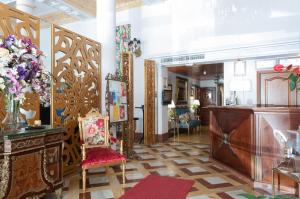 a lobby with a reception desk and a room with flowers at Adriano Boutique Sevilla in Seville