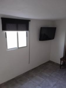 a white room with a television and a window at Casa lucas in Almáciga