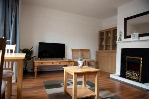 uma sala de estar com televisão e lareira em Tillyard Retreat, Ground Floor Apartment Cambridge em Cherry Hinton