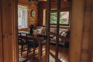 een eetkamer met een tafel en een bank bij Mountain Cottage Lubomierz in Lubomierz