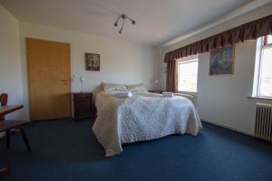 a bedroom with a bed and a window at Hotel Breidavik in Breiðavík