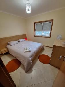 - une chambre avec un grand lit et une fenêtre dans l'établissement cerca do casal, à Santo Tirso