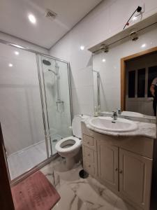 uma casa de banho com um WC, um chuveiro e um lavatório. em cerca do casal em Santo Tirso