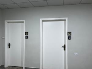 two white doors in a room with a wall at Downtown Inn Madaba in Madaba