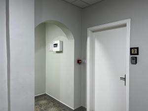 a white hallway with a door and a wall at Downtown Inn Madaba in Madaba