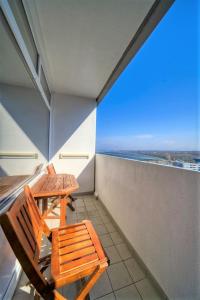 2 Holzstühle auf einem Balkon mit Aussicht in der Unterkunft Ferienpark - Haus C, App 0C1204 in Heiligenhafen