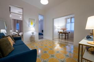 sala de estar con sofá azul y suelo amarillo en La Fenice - Mosaic Home, en Trapani