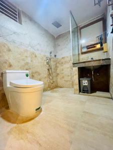 a bathroom with a toilet and a shower and a sink at Dreamers Paradise in Jaliapāra