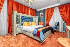 a bedroom with a king sized bed and red curtains at Manor Luxury Hotel Baku in Baku