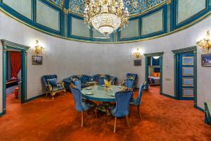 a dining room with a table and chairs and a chandelier at Manor Luxury Hotel Baku in Baku