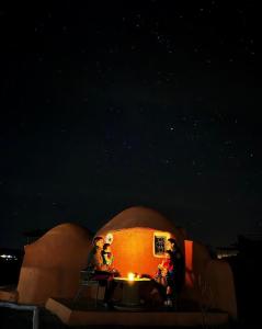 um grupo de pessoas sentadas num iglu à noite em Lekechdomes la terre des bédouins em Jaïdat