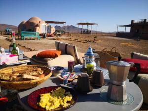 uma mesa com comida no deserto em Lekechdomes la terre des bédouins em Jaïdat