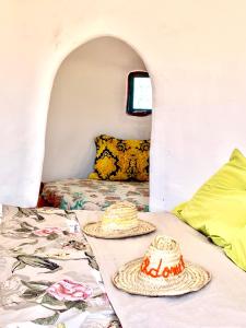 dois chapéus numa mesa numa casa minúscula em Lekechdomes la terre des bédouins em Jaïdat