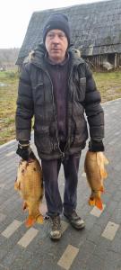 un homme dans une veste debout à côté de deux animaux dans l'établissement A&G SODYBA CAMP žvejų kampelis, à Plungė