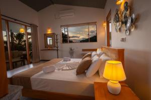 a bedroom with a large bed with a lamp at Hotel Bay Watch Unawatuna in Unawatuna