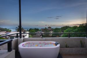 a bath tub on a balcony with a view of the ocean at Hotel Bay Watch Unawatuna in Unawatuna