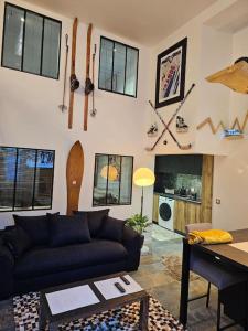 Loft 6 couchages (4+2) في كوتيريه: غرفة معيشة مع أريكة وجدار مع زلاجات